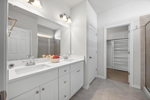 full bath with tile patterned flooring, a sink, a shower stall, and double vanity