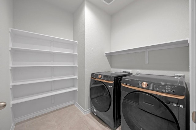 laundry area with laundry area, baseboards, washer and dryer, and tile patterned floors