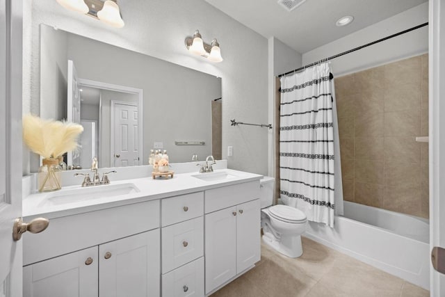 full bathroom featuring double vanity, a sink, toilet, and tile patterned floors