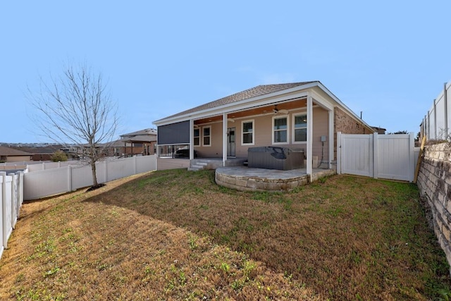 back of property featuring a patio, a fenced backyard, a sunroom, and a hot tub