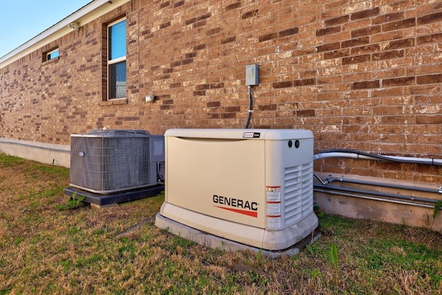 details featuring brick siding, a power unit, and central air condition unit