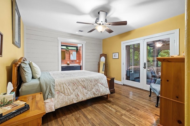 bedroom featuring wood walls, wood finished floors, visible vents, access to outside, and french doors