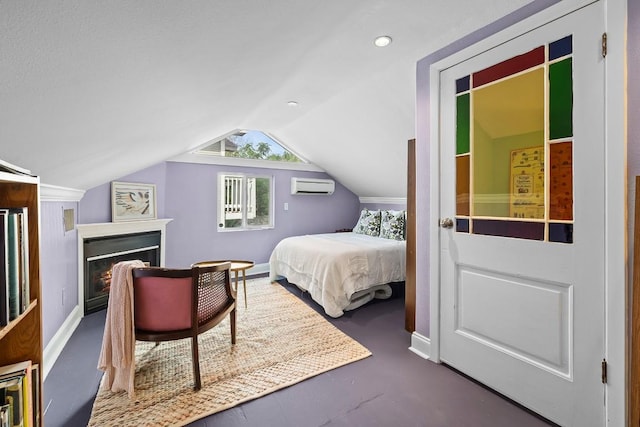 bedroom with a warm lit fireplace, a wall unit AC, vaulted ceiling, and baseboards