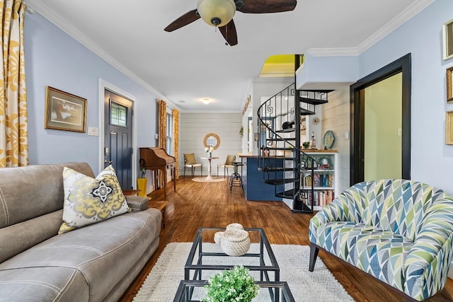 living room featuring stairs, a ceiling fan, crown molding, and wood finished floors