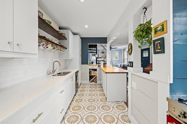 kitchen featuring tasteful backsplash, white cabinetry, open shelves, and a sink