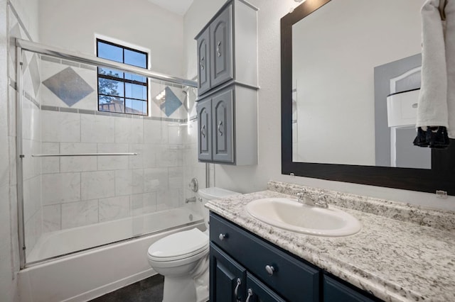 bathroom with toilet, enclosed tub / shower combo, and vanity