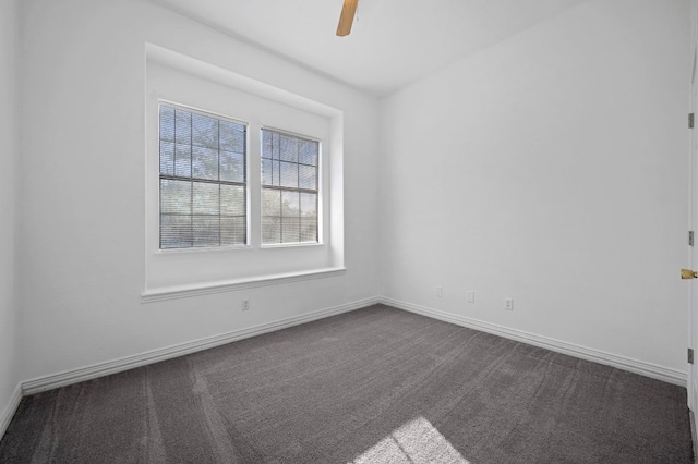 empty room featuring ceiling fan, baseboards, and dark colored carpet