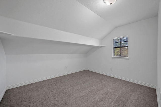 additional living space with carpet floors, baseboards, and lofted ceiling