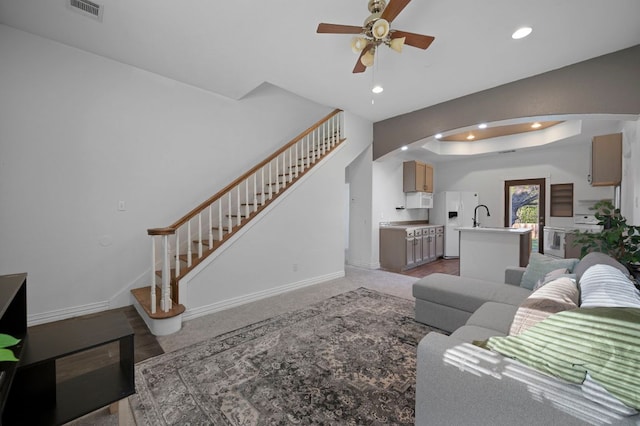 living room featuring recessed lighting, a raised ceiling, visible vents, stairway, and baseboards