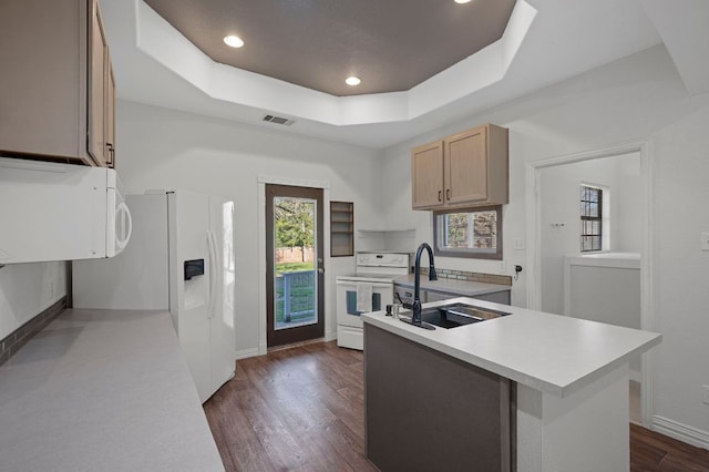 106 Park Dr, Bastrop, TX 78602 - kitchen featuring white appliances, light countertops, a raised ceiling, dark wood-style floors, and a kitchen island with sink