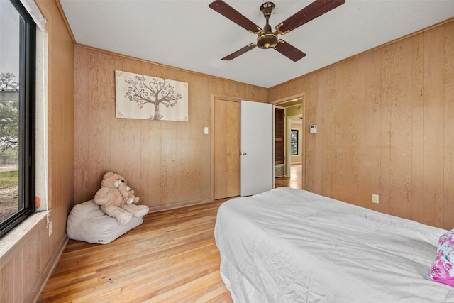 1876 Rocky Rd, Blanco, TX 78606 - bedroom with wooden walls, light wood-style flooring, and a ceiling fan