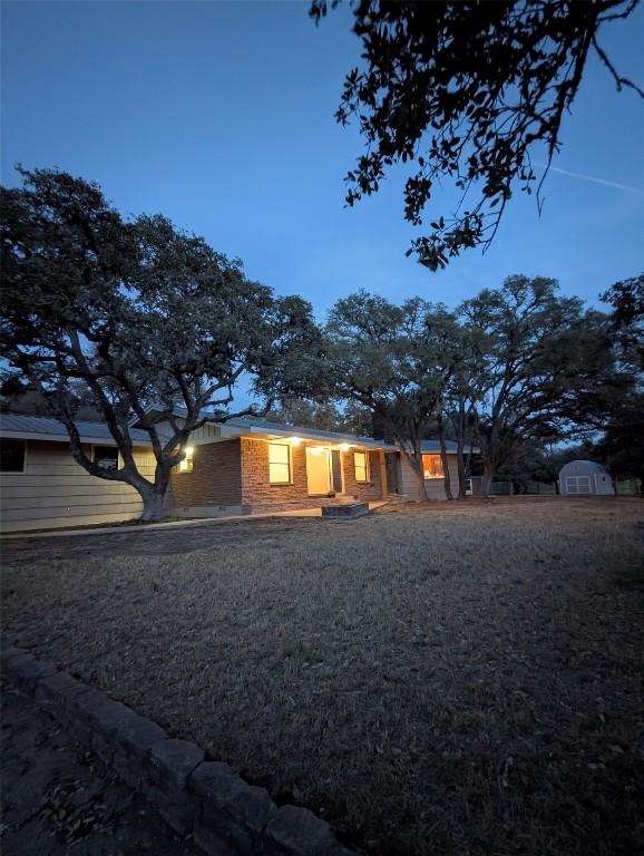 1876 Rocky Rd, Blanco, TX 78606 - view of front facade featuring a storage unit and brick siding