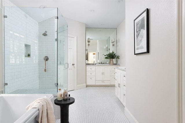 full bathroom with a stall shower, baseboards, a soaking tub, and vanity