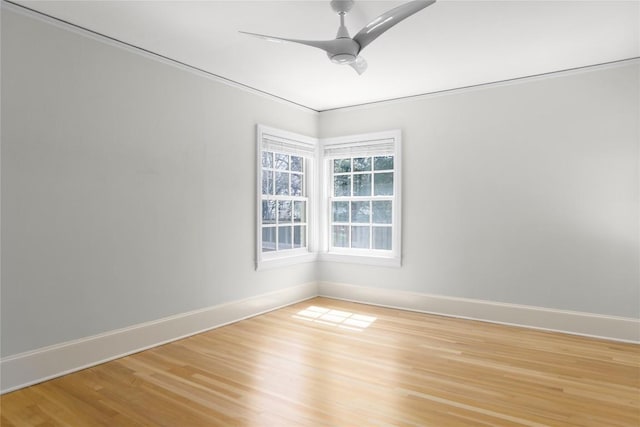 spare room with ceiling fan, light wood-style flooring, and baseboards