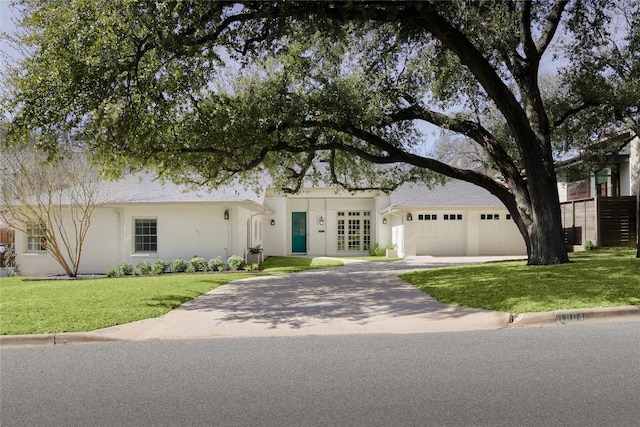 view of front of house featuring an attached garage, driveway, and a front lawn