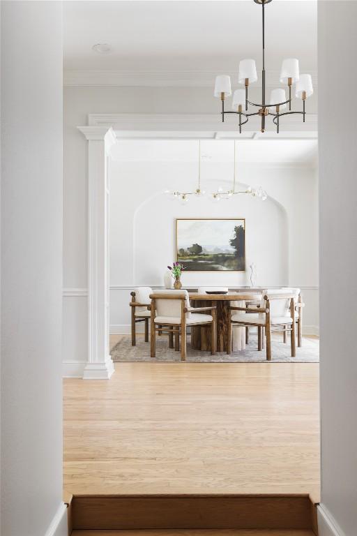 dining space with baseboards, crown molding, and wood finished floors