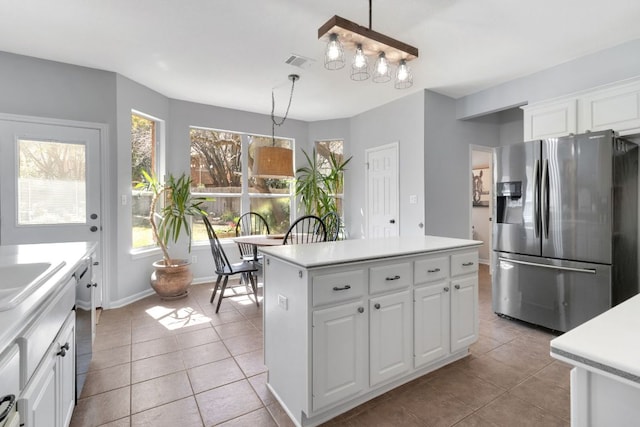 kitchen with light tile patterned floors, visible vents, white cabinetry, light countertops, and appliances with stainless steel finishes