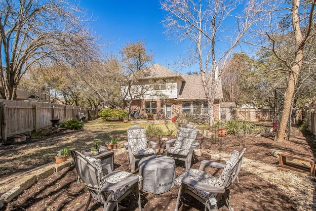 exterior space featuring brick siding, roof with shingles, and a fenced backyard