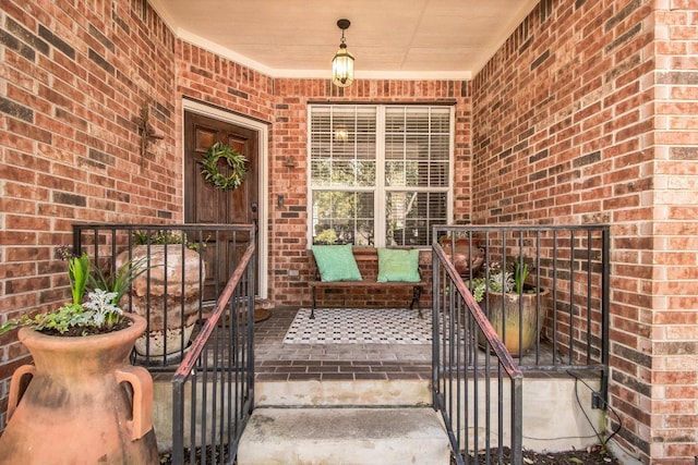 property entrance with covered porch and brick siding