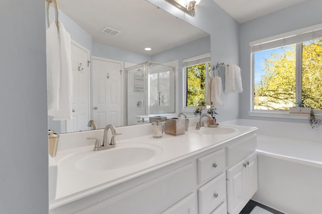 full bath featuring visible vents, a sink, a shower stall, and double vanity