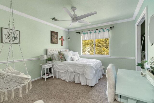 carpeted bedroom featuring visible vents, crown molding, and ceiling fan