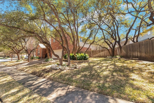 view of yard with driveway and fence