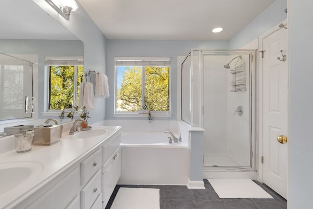 full bath featuring double vanity, a garden tub, tile patterned flooring, a shower stall, and a sink