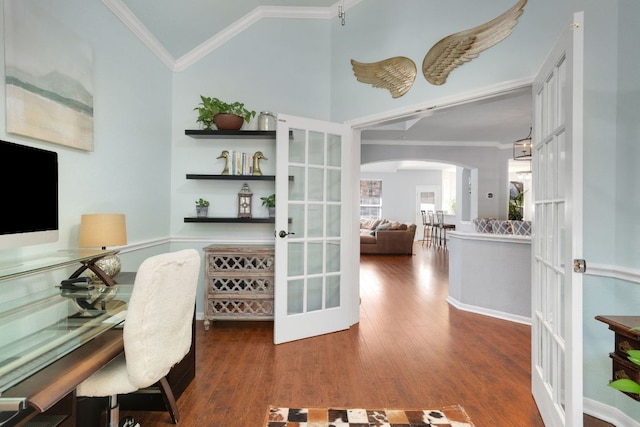 home office with arched walkways, ornamental molding, wood finished floors, vaulted ceiling, and french doors