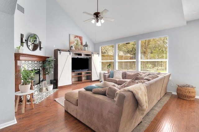 living area featuring visible vents, a ceiling fan, wood finished floors, high vaulted ceiling, and baseboards