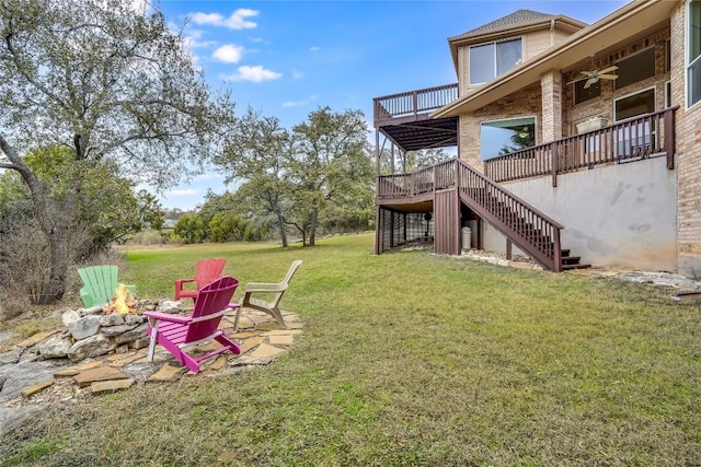 view of yard featuring stairway, a fire pit, a ceiling fan, and a wooden deck