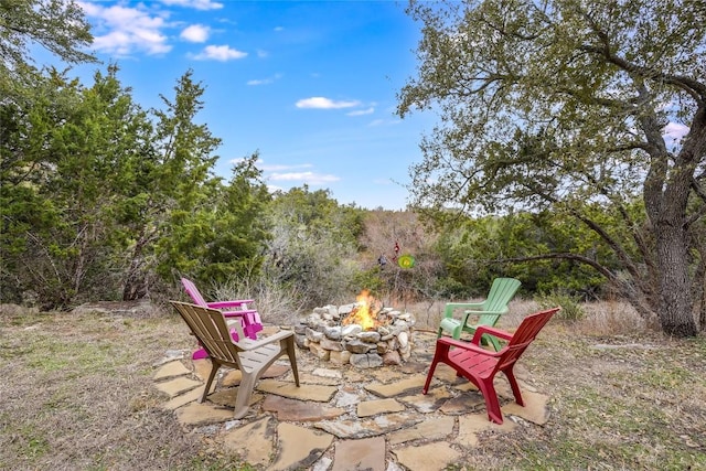 view of patio / terrace featuring a fire pit and a forest view