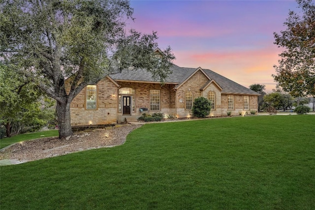 view of front of home featuring a front lawn and brick siding