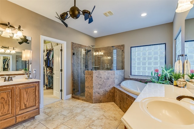 bathroom with a stall shower, two vanities, a sink, and a bath