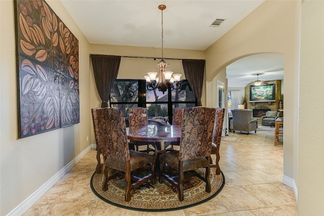 dining area with arched walkways, a fireplace, visible vents, a chandelier, and baseboards