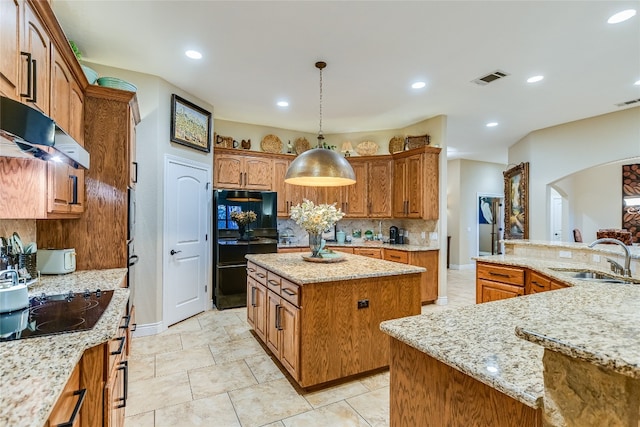 kitchen featuring recessed lighting, a kitchen island, a sink, backsplash, and black appliances