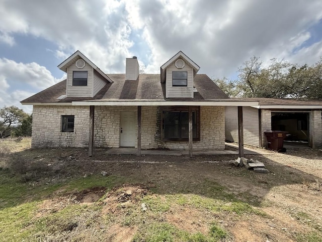 view of front of home featuring stone siding, covered porch, and a chimney