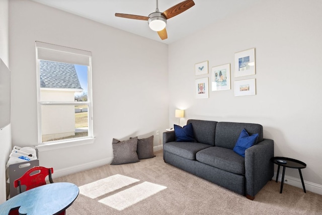 living room with carpet floors, baseboards, and a ceiling fan