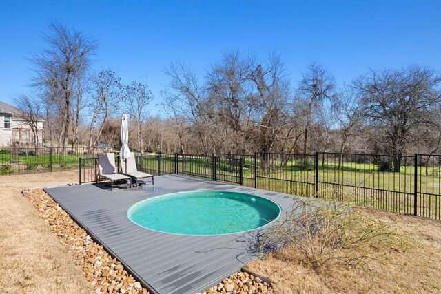 view of pool featuring fence and a yard