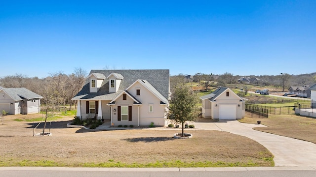 view of front of home with a shingled roof, a front yard, fence, and driveway