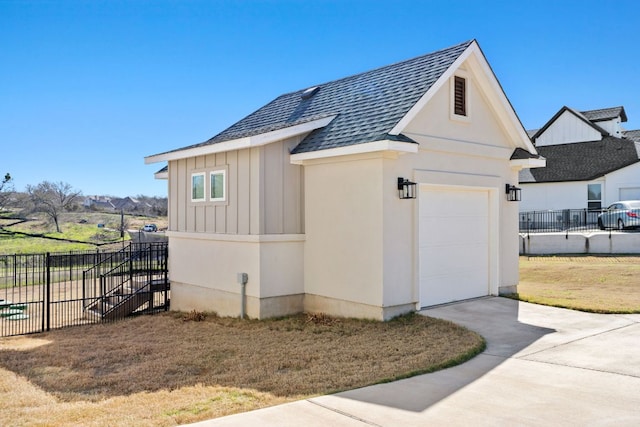 view of home's exterior featuring driveway, a garage, a shingled roof, fence, and board and batten siding