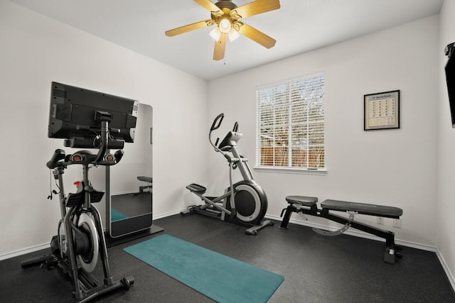 exercise room with a ceiling fan and baseboards