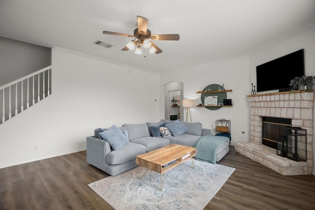 living room featuring ornamental molding, visible vents, stairs, and wood finished floors