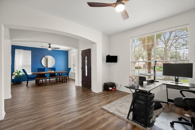 office with arched walkways, ceiling fan, wood finished floors, and baseboards