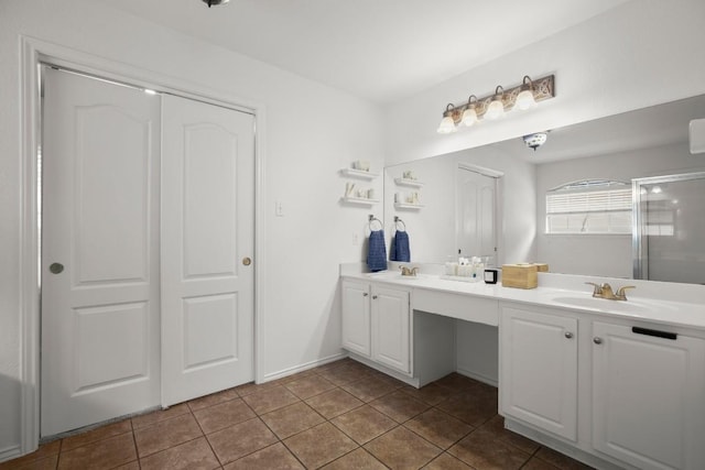 bathroom featuring double vanity, an enclosed shower, a sink, and tile patterned floors