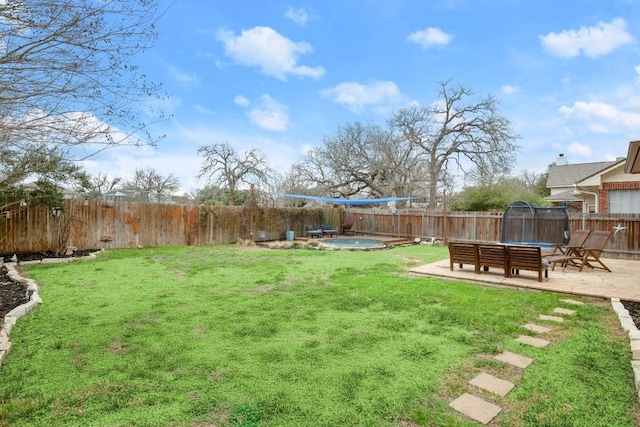 view of yard featuring a trampoline, a patio area, and a fenced backyard