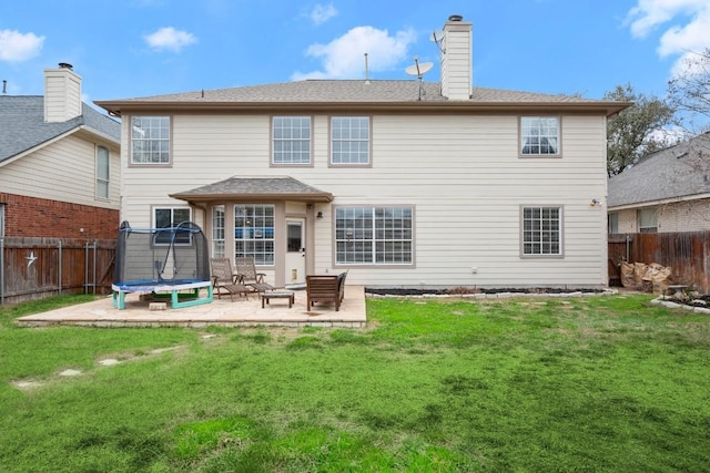 back of house featuring a fenced backyard, a trampoline, a lawn, and a patio