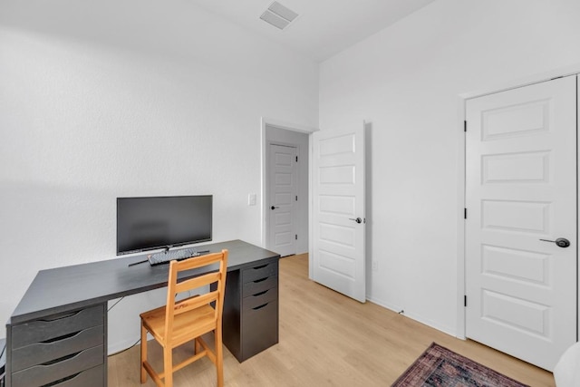 office space featuring light wood finished floors and visible vents