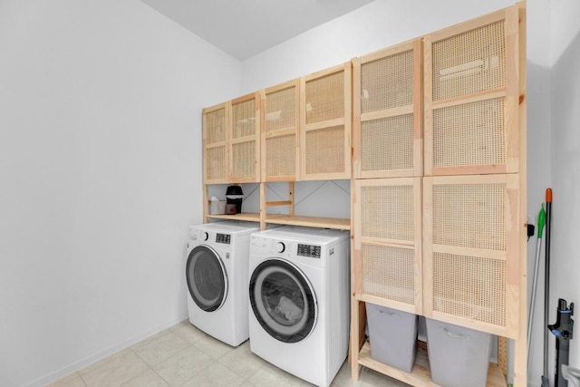 laundry room with cabinet space, washer and clothes dryer, and light tile patterned flooring