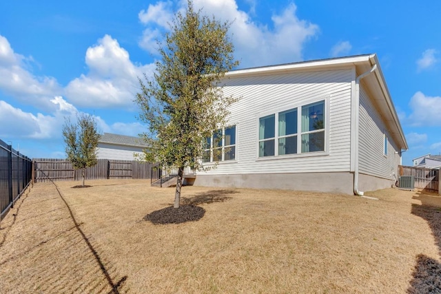 back of house featuring a fenced backyard and central AC unit