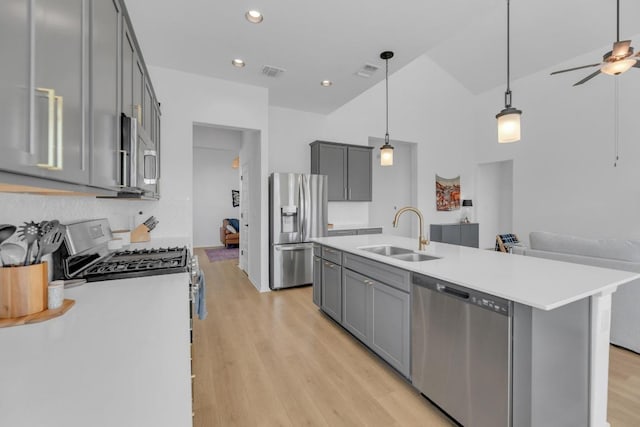 kitchen featuring visible vents, stainless steel appliances, a sink, and gray cabinetry